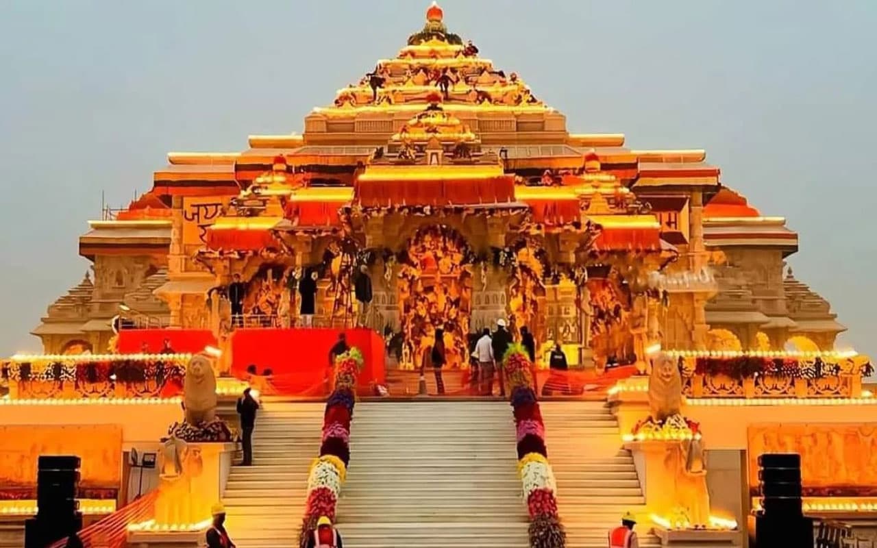 Ram Mandir in Ayodhya lit up at dusk with flower garlands on the steps
